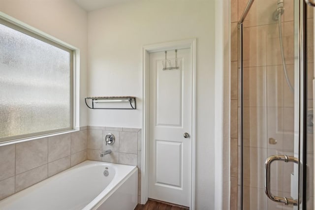 bathroom featuring hardwood / wood-style flooring, separate shower and tub, and a wealth of natural light