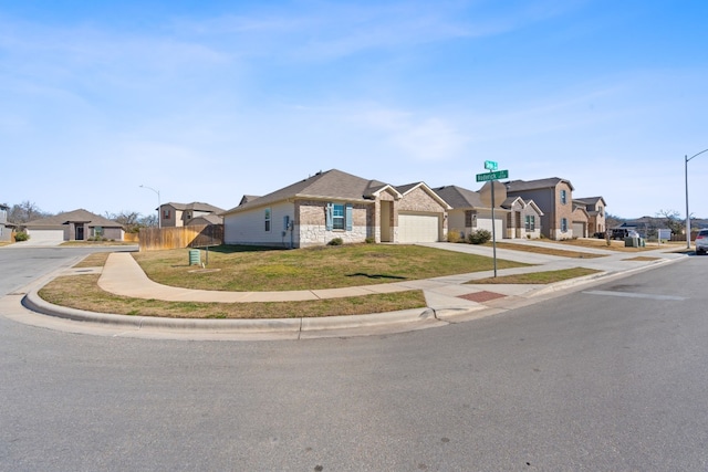 view of front of home with fence, stone siding, driveway, a residential view, and a front yard