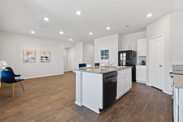 kitchen featuring black appliances, a center island with sink, visible vents, and dark wood finished floors