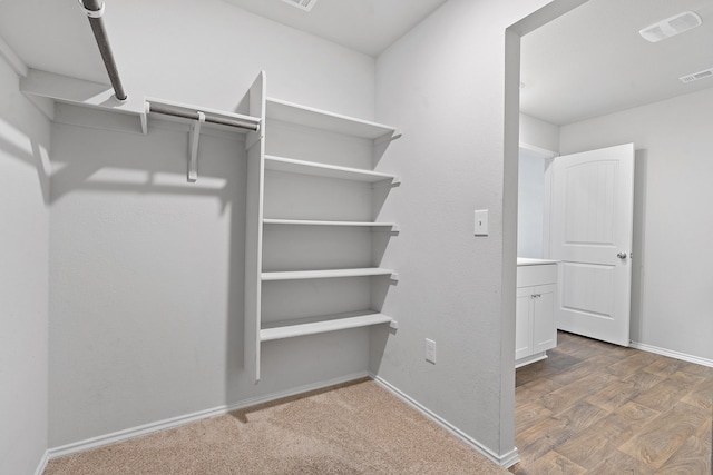 spacious closet with dark wood-style floors and visible vents