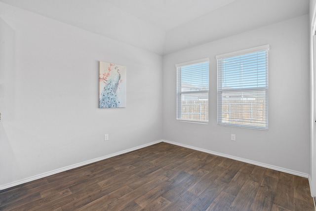 spare room with dark wood-style flooring and baseboards