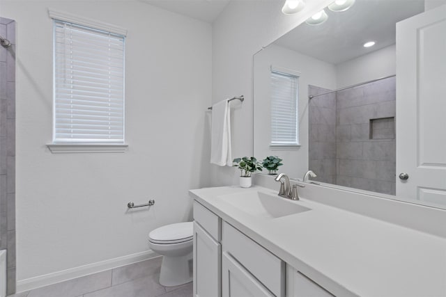 bathroom featuring vanity, tiled shower, tile patterned floors, and toilet