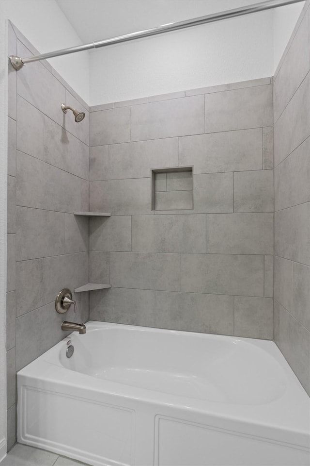 bathroom featuring tiled shower / bath combo and tile patterned flooring