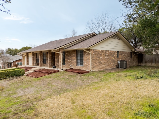 rear view of property with a lawn and central air condition unit