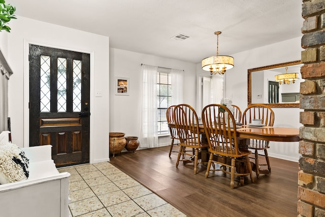 dining area with hardwood / wood-style flooring and a chandelier