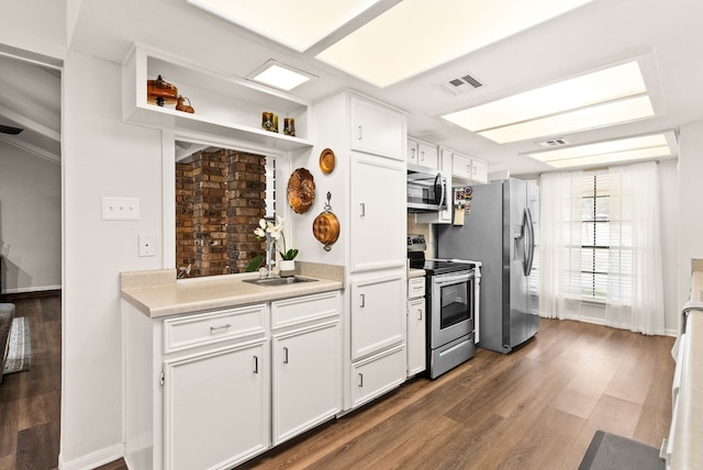 kitchen featuring stainless steel appliances, white cabinetry, sink, and dark hardwood / wood-style flooring