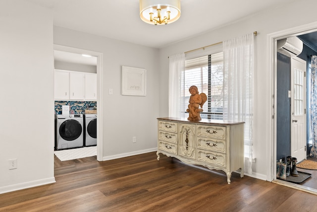 laundry room with cabinets, hardwood / wood-style floors, washing machine and dryer, and a wall unit AC