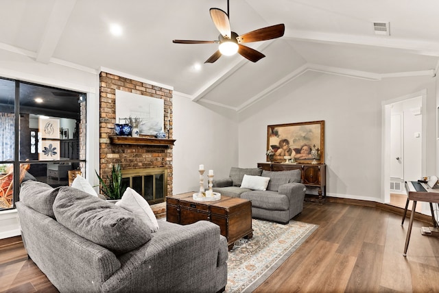 living room featuring lofted ceiling with beams, a brick fireplace, hardwood / wood-style flooring, and ceiling fan