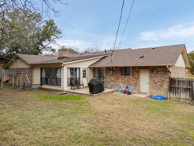 rear view of property with a lawn, a patio, and a playground