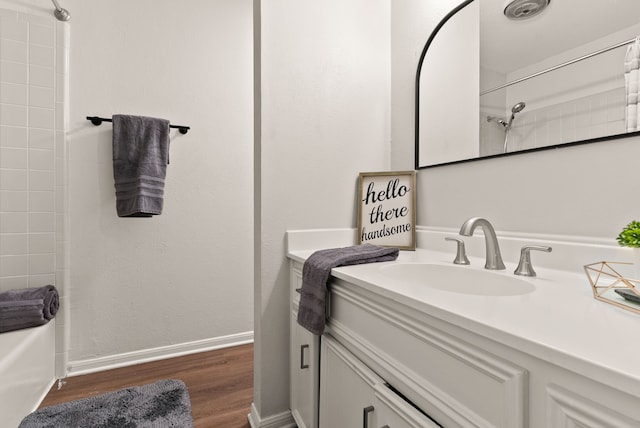 bathroom featuring hardwood / wood-style flooring, vanity, and tub / shower combination