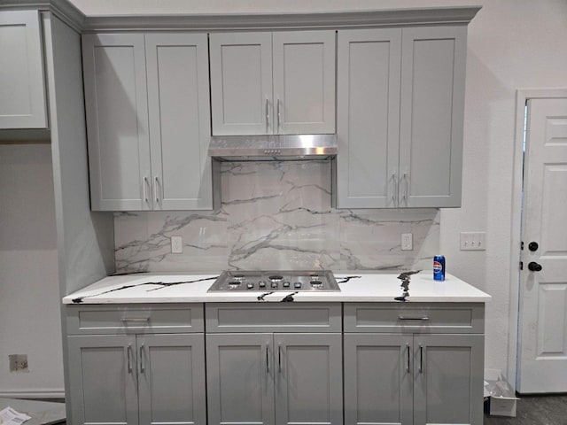 kitchen featuring gray cabinets, stainless steel gas cooktop, and backsplash