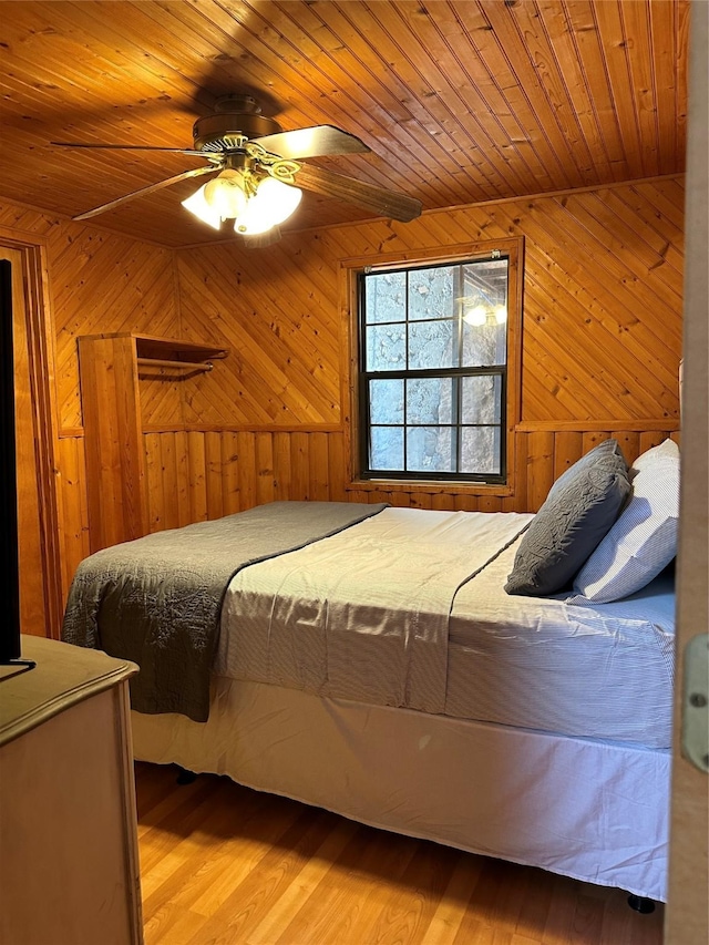 bedroom featuring wood ceiling, ceiling fan, and wooden walls