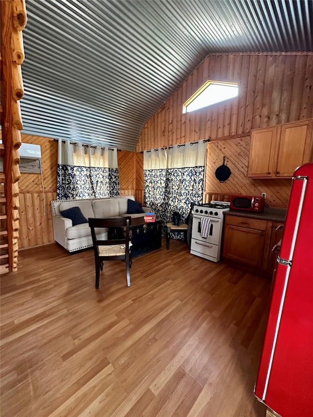 interior space featuring lofted ceiling, hardwood / wood-style floors, and wood walls