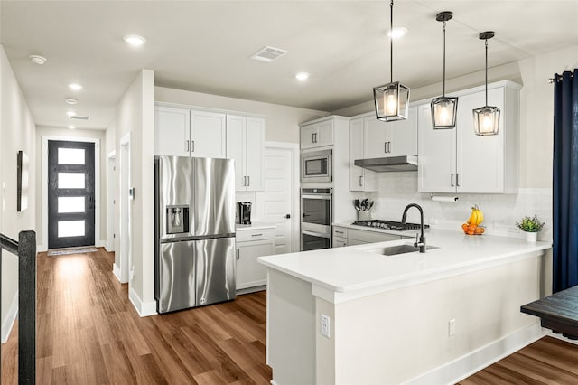 kitchen featuring white cabinetry, dark hardwood / wood-style flooring, stainless steel appliances, and kitchen peninsula