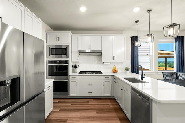 kitchen featuring sink, decorative light fixtures, white cabinets, and appliances with stainless steel finishes