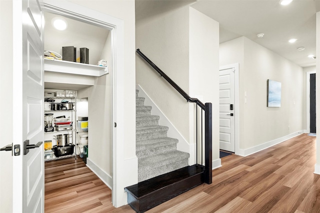 staircase with hardwood / wood-style flooring