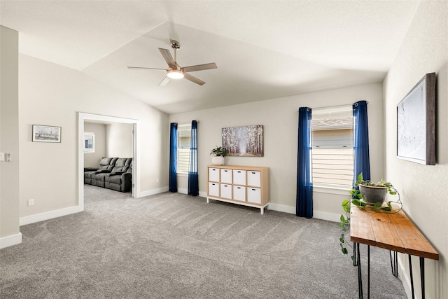 living area with carpet floors, vaulted ceiling, and ceiling fan