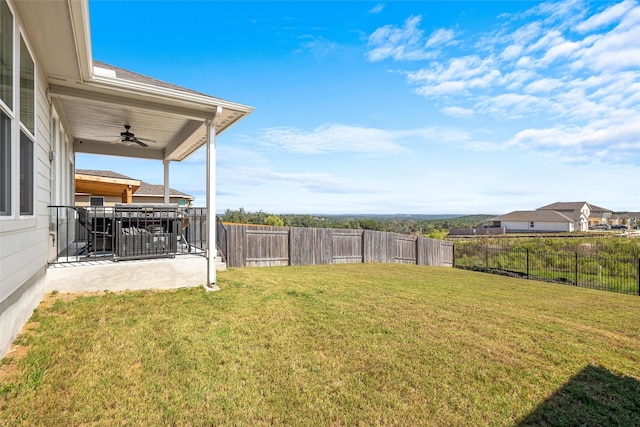 view of yard with ceiling fan and a patio