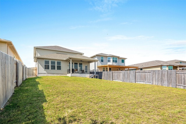 back of house featuring a patio area and a lawn