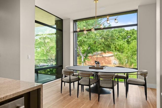 dining space featuring light hardwood / wood-style flooring, beverage cooler, and a wall of windows