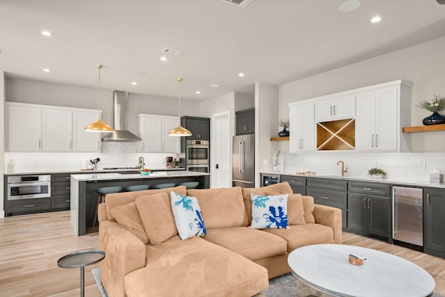 living room featuring light hardwood / wood-style flooring and wet bar