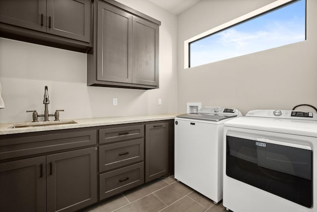 clothes washing area with cabinets, separate washer and dryer, sink, and dark tile patterned floors