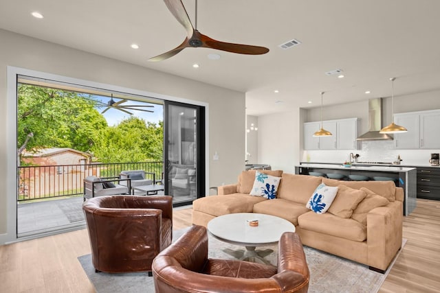 living room with light hardwood / wood-style floors and ceiling fan