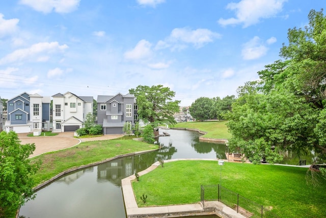 view of property's community with a yard and a water view