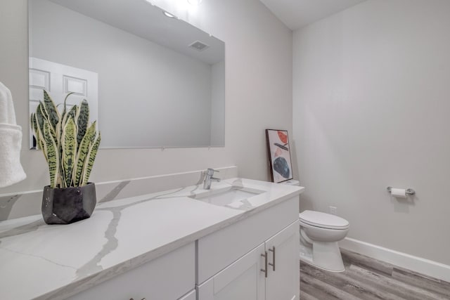 bathroom with vanity, hardwood / wood-style flooring, and toilet