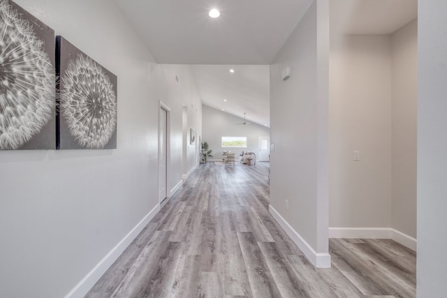 hall featuring vaulted ceiling and light wood-type flooring