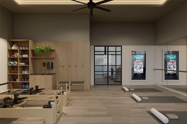 interior space featuring a high ceiling, ceiling fan, and light wood-type flooring