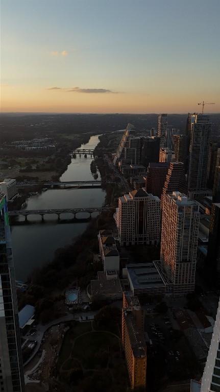 aerial view at dusk featuring a water view