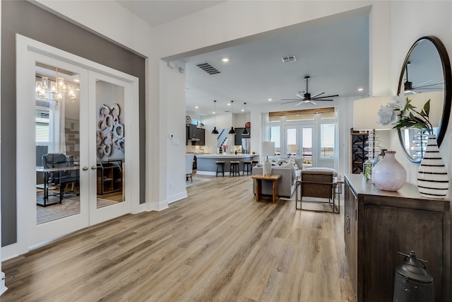 living room with french doors, ceiling fan, and light wood-type flooring