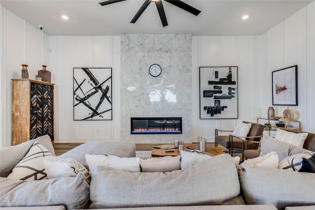 living room featuring hardwood / wood-style flooring, a fireplace, and ceiling fan