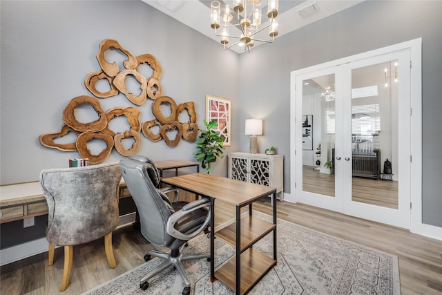 office space with an inviting chandelier, wood-type flooring, and french doors