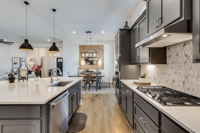 kitchen featuring sink, decorative light fixtures, light hardwood / wood-style flooring, gray cabinets, and stainless steel appliances