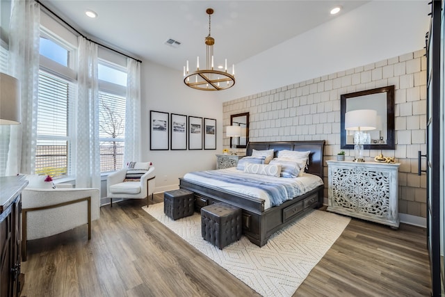 bedroom with an inviting chandelier and dark hardwood / wood-style floors