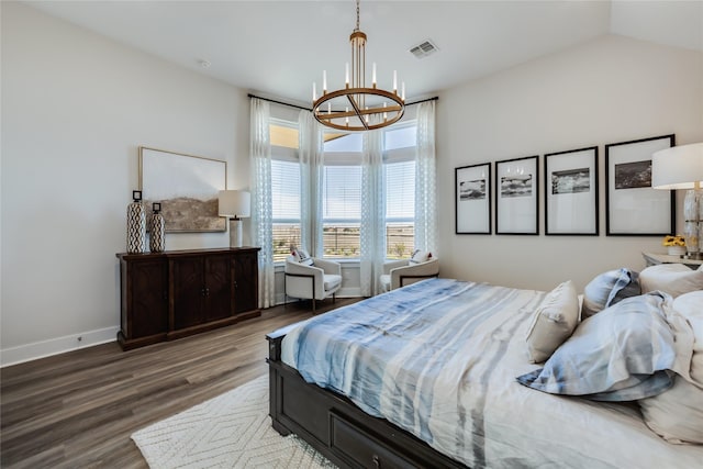 bedroom with vaulted ceiling, hardwood / wood-style floors, and an inviting chandelier