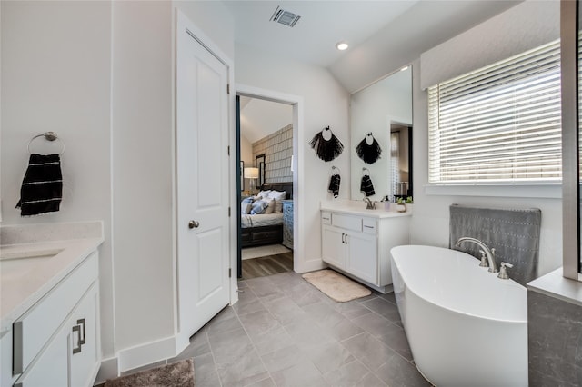 bathroom with vanity, tile patterned flooring, and a bathtub