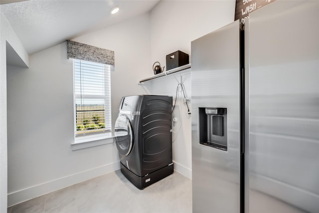 washroom with washer / dryer and light tile patterned flooring