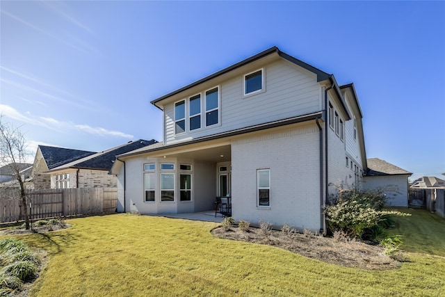 rear view of property with a patio and a lawn