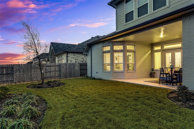 yard at dusk featuring a patio area