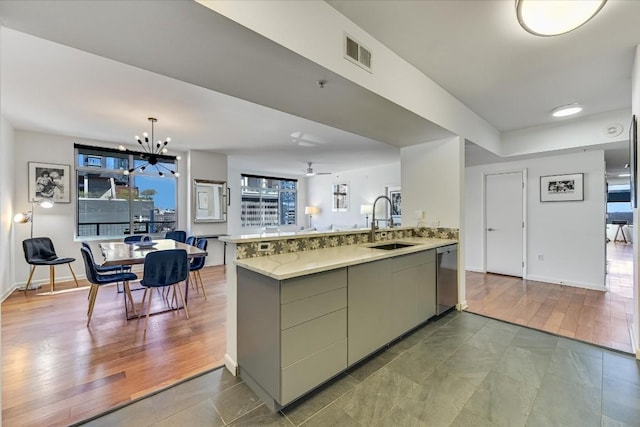 kitchen with hardwood / wood-style flooring, sink, stainless steel dishwasher, and kitchen peninsula