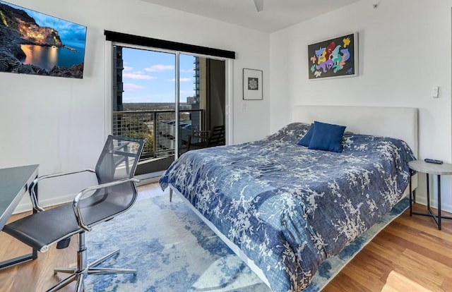 bedroom featuring wood-type flooring and access to outside