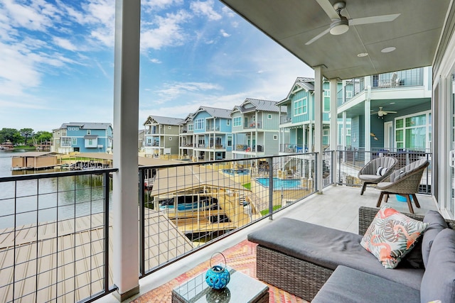 balcony with a water view and ceiling fan