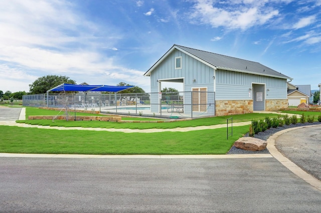 view of property's community with a pool and a yard