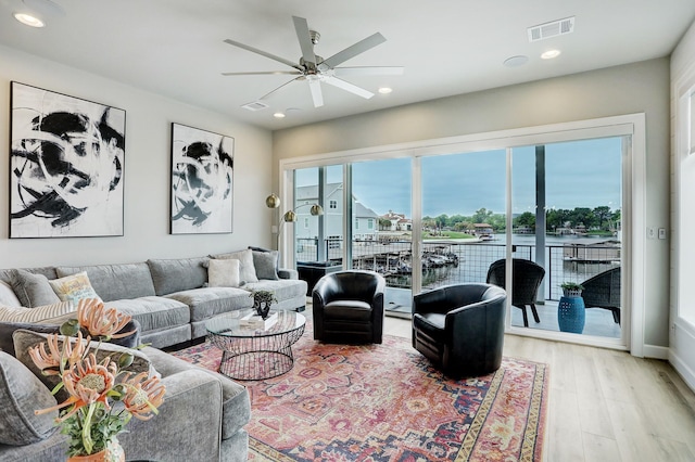 living room featuring light hardwood / wood-style flooring and ceiling fan