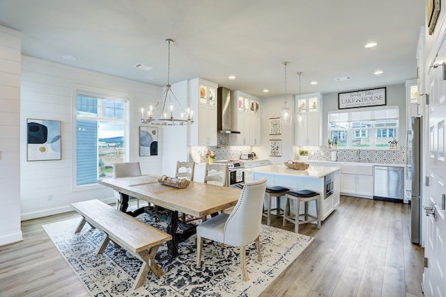 dining room with light hardwood / wood-style flooring and a notable chandelier