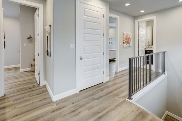 hallway with light hardwood / wood-style floors