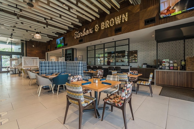 tiled dining space with wood walls and a high ceiling